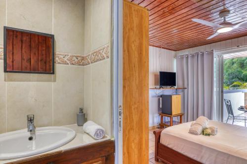 a bathroom with a sink and a bed and a tub at L'Escale Royale in Salazie