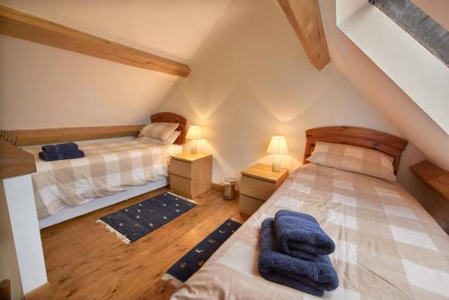 a attic bedroom with two beds and two lamps at Barn Cottages at Lacock in Lacock