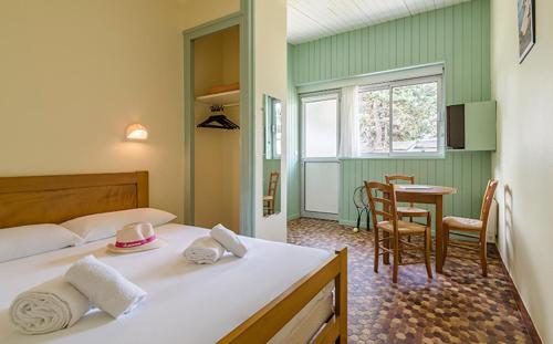 a bedroom with a bed and a table and chairs at Azureva Club Hauteville in Hauteville-sur-Mer