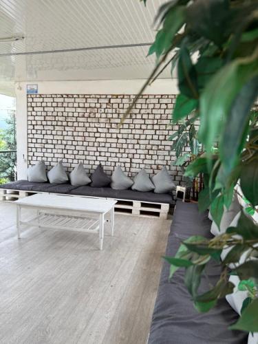 a white bench in a room with a brick wall at Гостевой дом Асель in Cholpon-Ata