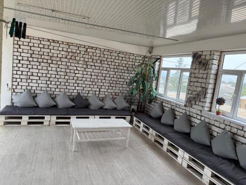 a room with couches and a table and some windows at Гостевой дом Асель in Cholpon-Ata