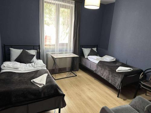 a bedroom with two beds and a window and a chair at Paradise Inn Kazbegi in Kazbegi