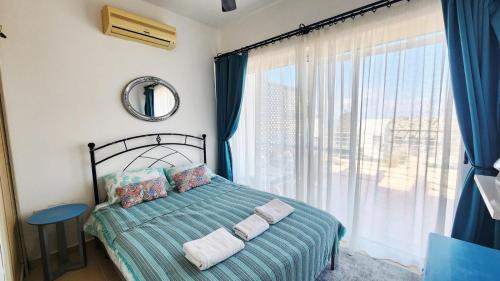 a bedroom with a bed and a large window at Apartament Palm Bay View Esentepe Bahceli in Kyrenia