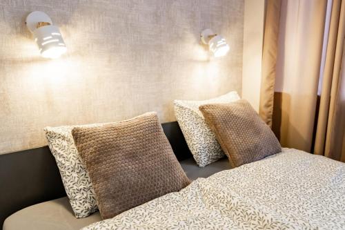 a bed with two pillows and two lights on the wall at Super Central Modern Studio #Palace View #55''Smart TV #Fast Wi-Fi #Metro in Warsaw