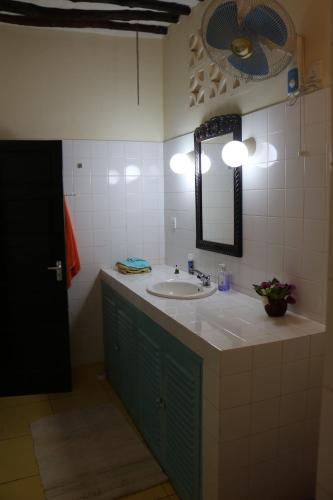 uma casa de banho com um lavatório e um espelho em Villa Madinina em Diani Beach