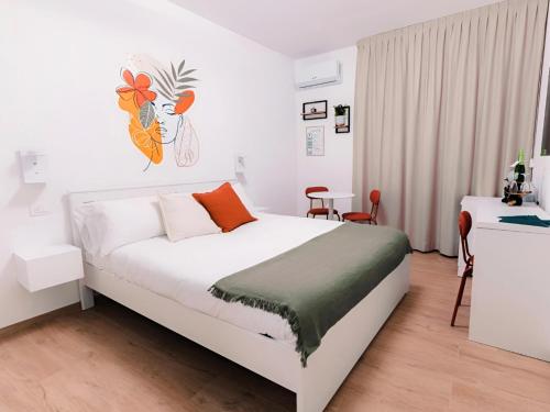 a white bedroom with a bed and a table at La tana del Furlo in Acqualagna