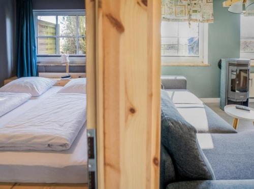 a bedroom with two beds and a couch and a television at FerienGut Gaarz - Im Park 3 in Göhl