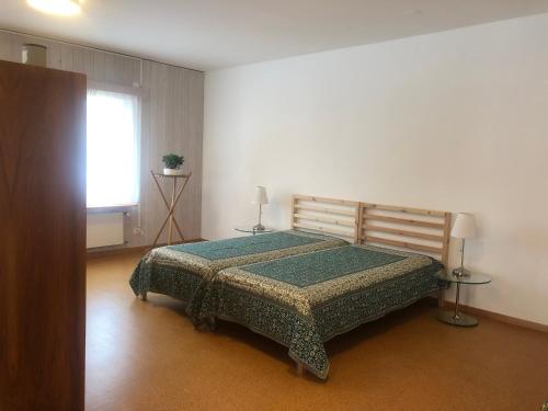 a bedroom with a bed with a green comforter and a window at Buddha-Loft in Solothurn