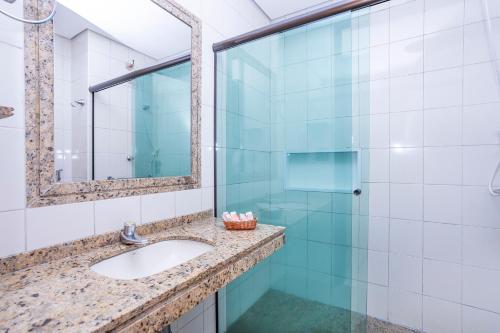 a bathroom with a sink and a mirror at Hotel Aojesp in Caraguatatuba