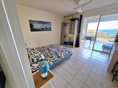a bedroom with a bed and a view of the ocean at Studio vu sur les caraïbes in Les Trois-Îlets