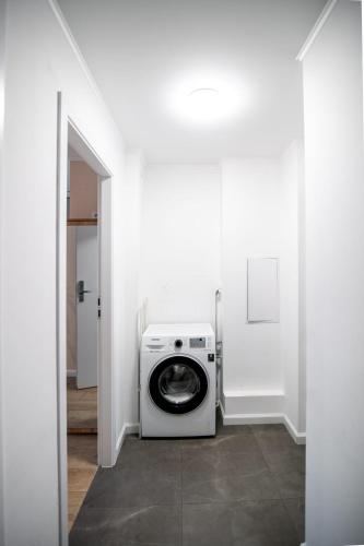 a washer and dryer in a white room at Super Central Modern Studio #Palace View #55''Smart TV #Fast Wi-Fi #Metro in Warsaw