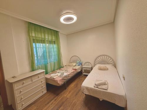a room with two beds and a dresser and a window at Mar y Golf in Orihuela Costa