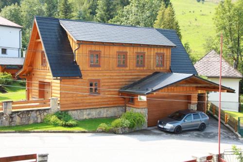 a wooden house with a car parked in front of it at Drevenice Osádka in Osádka