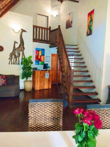 a living room with a staircase with giraffes on the wall at Libra Lodge & Spa - Randburg, Johannesburg in Sandton