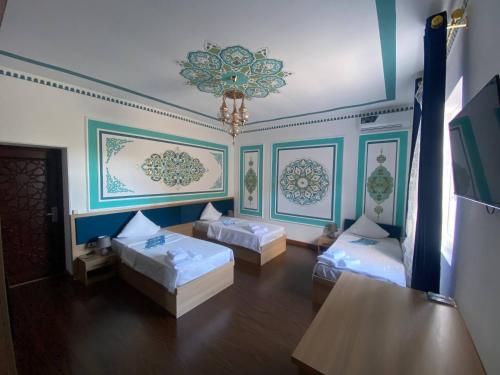 a living room with two beds and a chandelier at Gavhar Boutique Hotel in Khiva