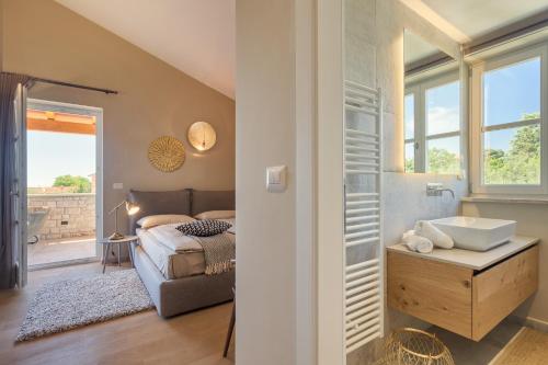 a bedroom with a bed and a bathroom with a sink at Villa Natalie in Vabriga