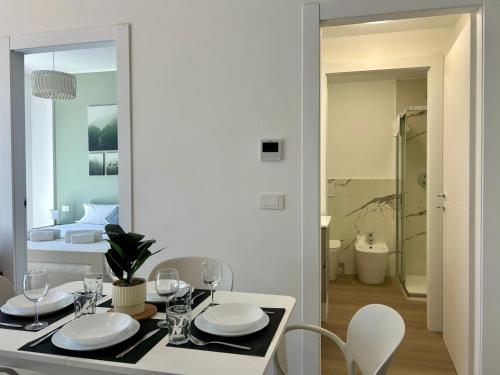 a dining room with a table and chairs and a bedroom at Bressanone Apartments in Milan