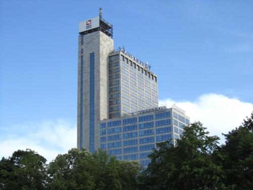 a tall building with trees in front of it at Courtyard by Marriott Katowice City Center in Katowice