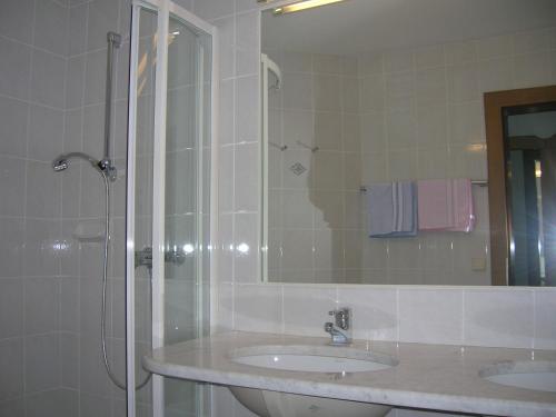 a bathroom with a sink and a shower with a mirror at Pension Gertraud in Bad Kleinkirchheim
