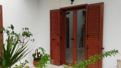 una puerta de madera en el lateral de un edificio en Casa del Gelso Mortelle, en Torre Faro