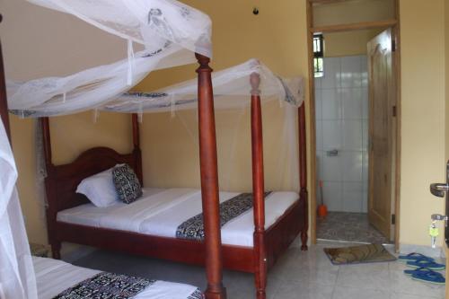 a bedroom with two bunk beds and a shower at Kibale Eco-Home in Bigodi