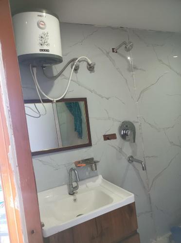 a bathroom with a sink and a lamp and a mirror at The Devine homestay in Ukhimath