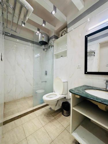 a bathroom with a toilet and a glass shower at Hotel The Grace Residency - Near Hotel Hyatt ,DLF MyPad, Gomtinagar, Lucknow in Lucknow