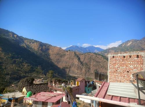 a view of a village with mountains in the background at The Devine homestay in Ukhimath