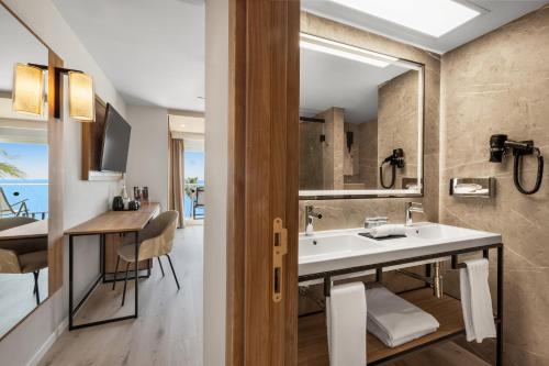 a bathroom with a sink and a mirror at Hotel Riu Palace Nautilus - Adults Only in Torremolinos