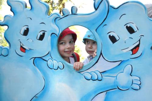 two children looking through a hole in a blue play structure at Hotel Restaurant Stöcklwirt in Sankt Johann im Pongau