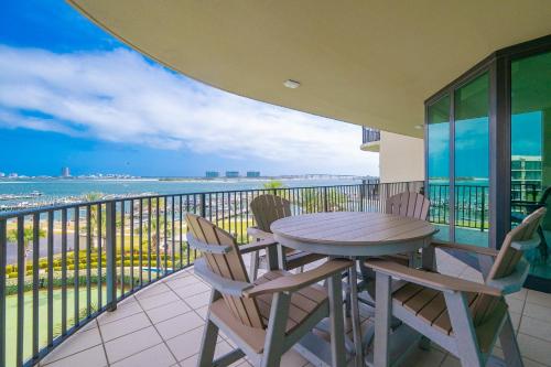 a table and chairs on a balcony with a view of the ocean at Phoenix on the Bay 1405 in Orange Beach