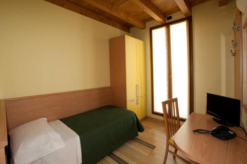 a room with a bed and a desk with a computer at Hotel Valbrenta in Limena