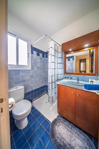 a bathroom with a toilet and a sink and a mirror at Villa Stella with Jacuzzi in Oroklini