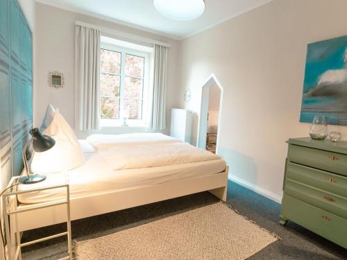 ein Schlafzimmer mit einem Bett, einer Kommode und einem Fenster in der Unterkunft Ostseeferien Evershof in Travemünde