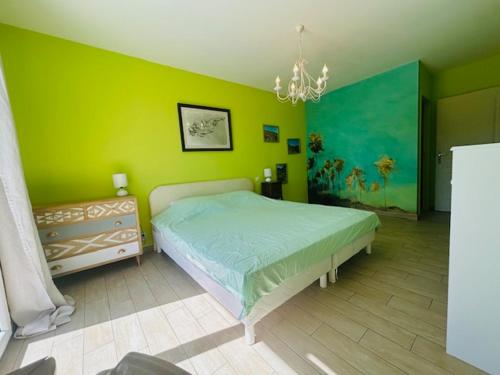 a green bedroom with a bed and a chandelier at A True Paradise for unforgettable vacation – Villa Pool and Sea View in Nice