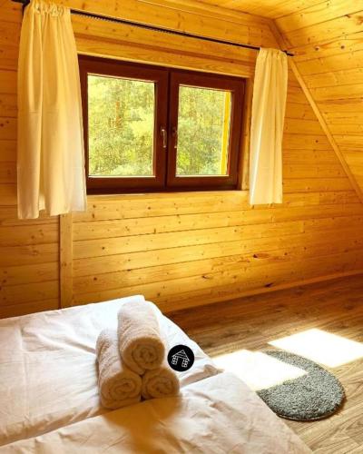 a bedroom with a bed with towels on it at Domki w Lipnicy in Lipnica