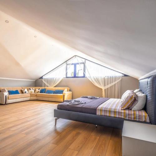 a attic bedroom with a bed and a couch at canyon villa in Kemer