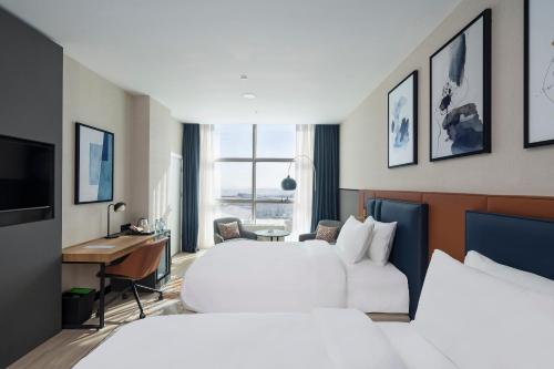 a hotel room with two beds and a desk at Crowne Plaza Istanbul West-Beylikduzu By IHG in Istanbul