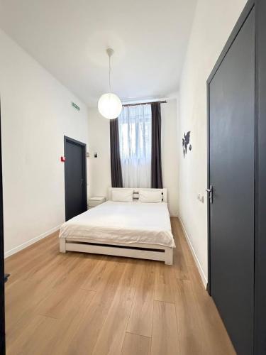 a white bedroom with a bed and a large window at Atlas Hotel in Poltava