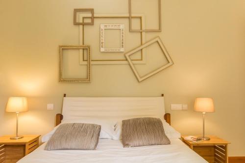 a bedroom with a white bed with two lamps at Gîte G175 in Grosville