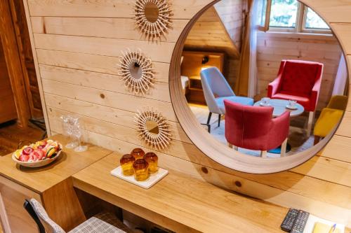 a mirror in a room with a table and chairs at Hotel Porto Tara in Žabljak