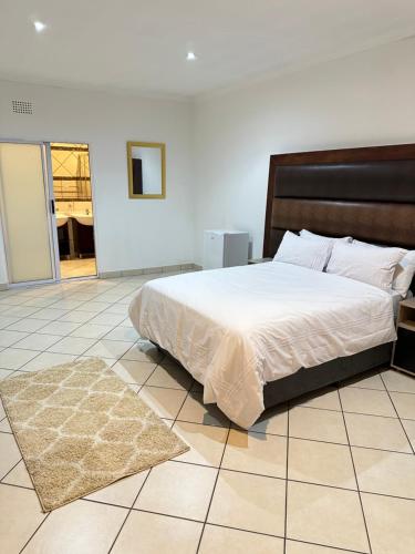 a bedroom with a bed and a rug on a tiled floor at Eagle Empire in Vereeniging