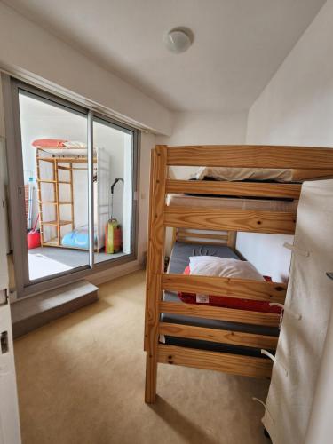 a bedroom with two bunk beds and a window at Les flos bleus in La Bernerie-en-Retz