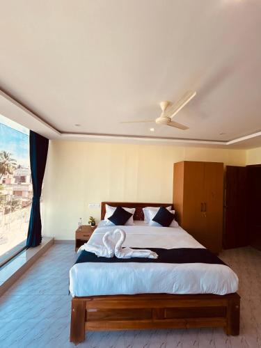 a bedroom with a large bed with a ceiling fan at Royal Inn in Mysore