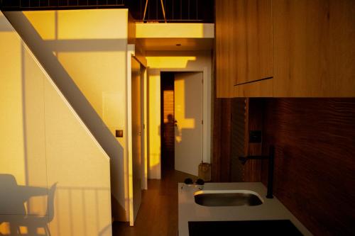 a bathroom with a sink and a hallway with a staircase at Casa de Sobreiros in Amarante