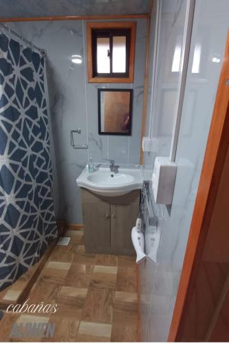 a bathroom with a sink and a mirror at Cabañas 2 Aliwen Lonquimay in Lonquimay