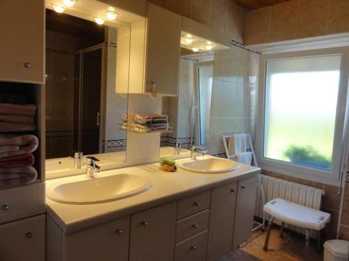 a bathroom with two sinks and a large mirror at Gîte G337 in Quibou
