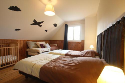 a bedroom with two beds and a crib at Gîte G40 in Marchésieux
