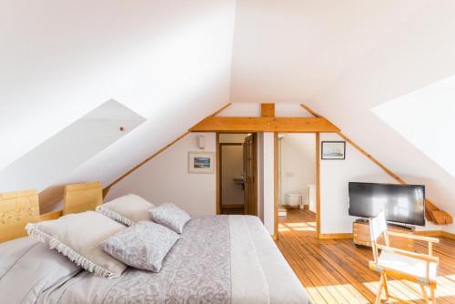 a attic bedroom with a bed and a television at Gîte G4 in Barfleur