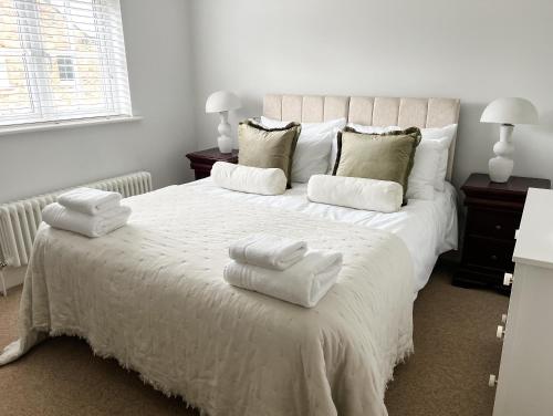 a bedroom with a white bed with towels on it at Windsor Mews by Stay Focused SA in Windsor